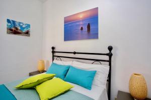利帕里利帕里伊尔维里诺蓝光城市公寓的一间卧室配有一张带蓝色和白色枕头的床