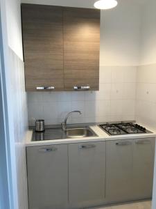 滨海波利尼亚诺Dimora的白色的厨房设有水槽和炉灶。