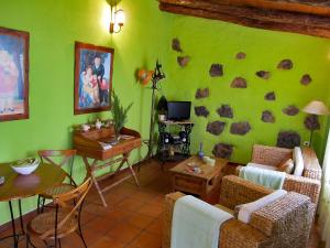 Las RosasGeranios Rojos II的客厅设有绿色的墙壁,上面有岩石