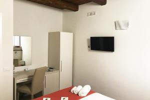 维博瓦伦蒂亚B&B Cerasarella的一间卧室配有一张床和一张书桌,墙上配有电视。