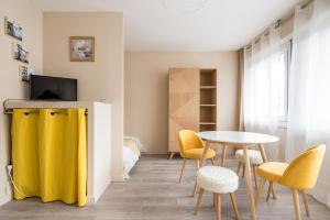 里昂Appartement Lyon Gerland - Enjoy in Lyon的客厅配有桌子和黄色椅子