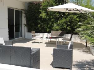 切萨雷奥港B&B Aloa的庭院配有桌椅和遮阳伞。