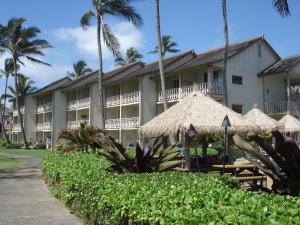 卡帕阿艾兰德尔海滨244号公寓的一座带遮阳伞和棕榈树的度假建筑