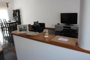 奥尔塔Casa das Marias的客厅设有1个带电视和桌子的柜台。