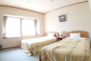 中之条糸園岛酒店的一间卧室设有两张床和窗户。
