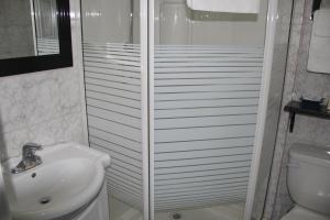 珀斯Perth Plaza Inn & Suites的带淋浴、盥洗盆和卫生间的浴室