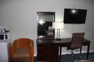 珀斯Perth Plaza Inn & Suites的一张位于酒店客房内的桌子,配有镜子和椅子