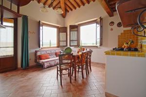 坎丕里亚麦利蒂玛Podere Tre Cipressi的厨房以及带桌椅的起居室。