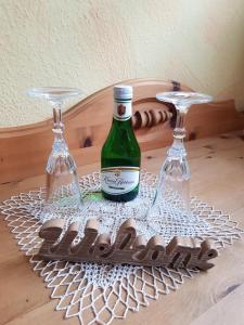 特里贝格Haus Krismann的桌子上放有一瓶葡萄酒和两杯酒