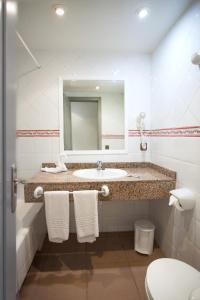 埃尔阿雷纳尔Hotel Cassandra的一间带水槽、镜子和卫生间的浴室