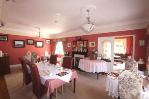 韦克斯福德枫叶小屋酒店的一间拥有红色墙壁和桌椅的用餐室