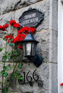 阿伯丁Denmore Guest House的石墙上红花的街道灯