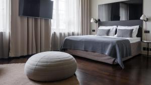 斯德哥尔摩Nobis Hotel Stockholm, a Member of Design Hotels™的一间卧室,前面配有一张带搁脚凳的床