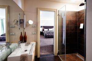 波茨坦卡佐宫殿酒店的浴室配有水槽、淋浴和浴缸。