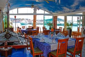 罗戈兹尼察罗戈兹尼察弗拉帕码头度假村的一间配备有蓝色桌椅和水的用餐室