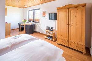 诺德奈Birkenhof的一间卧室配有一张床和一个木制橱柜