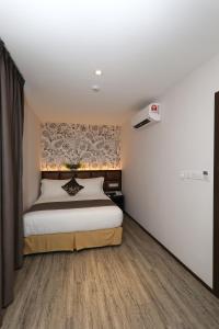 吉隆坡吉隆坡中心双M酒店的一间卧室设有一张床和一面墙