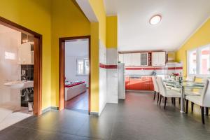 奥布罗瓦茨House Danica的厨房设有黄色的墙壁和桌椅