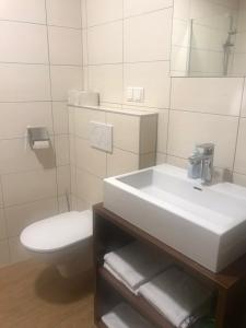 约伊斯施耐芬霍夫宾馆的浴室配有白色水槽和卫生间。