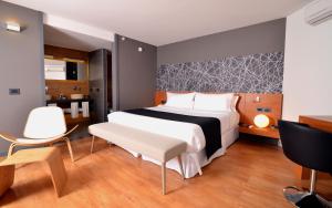 蒙得维的亚比特设计酒店的卧室配有一张床、一张桌子和椅子