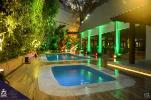 圣玛丽亚伊泰姆比宫酒店的一座绿灯建筑前的游泳池