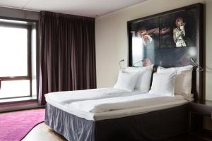 斯塔万格康福特茵酒店的卧室配有一张带白色床单和枕头的大床。