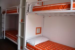 AbadínAlbergue Xabarín的一间卧室配有两张双层床,提供橙色床单