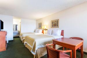 梅萨Travel Inn - Mesa的酒店客房设有两张床和一张桌子。