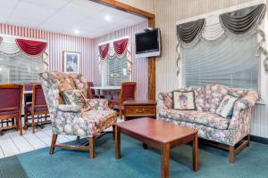 JonesvilleHamilton Inn Jonesville I-77的客厅配有两把椅子和电视