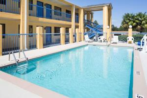 恩特普赖斯恩特普赖斯戴斯酒店的一座带椅子的度假村的游泳池和一座建筑