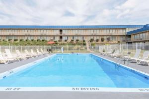 圣克莱尔斯维尔圣克莱斯维尔戴斯酒店的一座带椅子的大型游泳池和一座建筑