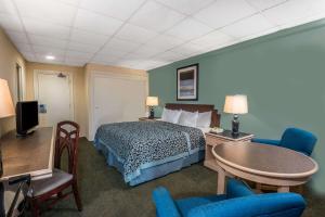 大西洋城大西洋城海滨浮桥戴斯酒店的酒店客房带一张床、一张桌子和椅子