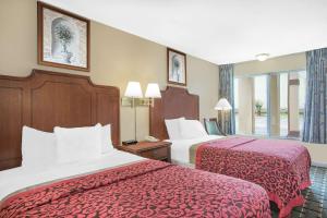 梅里迪恩Meridian Inn Hotel的酒店客房,配有两张带红色床单的床