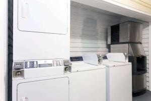 萨凡纳机场戴斯酒店的厨房配有白色的洗衣机和炉灶