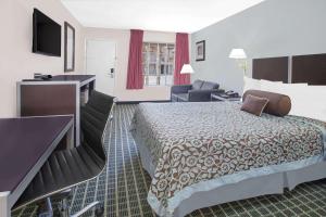 达拉斯Days Inn by Wyndham Market Center Dallas Love Field的配有一张床和一张书桌的酒店客房