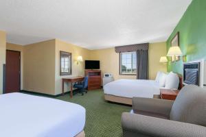 Great Bend戴斯大本德酒店的酒店客房配有两张床和一张书桌