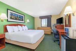 Great Bend戴斯大本德酒店的酒店客房设有一张大床和一张书桌。