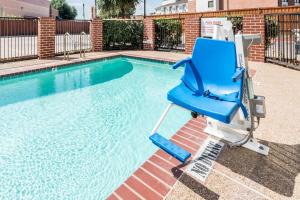 达拉斯达拉斯戴斯酒店及套房的游泳池旁的蓝色椅子