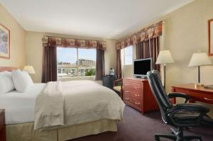 里士满温哥华机场戴斯酒店的酒店客房配有一张床、一张桌子和一把椅子。