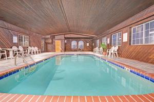 拉勒米拉勒米戴斯酒店的一座带椅子的木质建筑中的游泳池