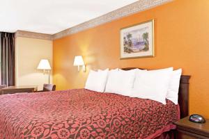 代托纳海滩Sunset Inn Daytona Beach的酒店客房,配有一张红色床罩的床
