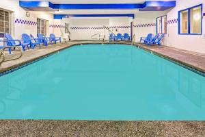格雷舍姆格雷欣戴斯套房酒店的一个带蓝色椅子的游泳池