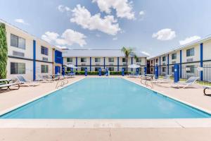 拉雷多拉雷多德克萨斯戴斯套房酒店的一座带椅子的游泳池以及一座建筑