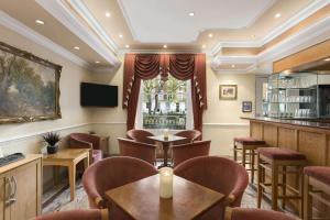 伦敦戴斯海德公园酒店的一间带桌椅的餐厅和一间酒吧