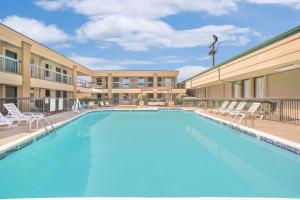 阿塔拉阿塔拉戴斯酒店的一座带椅子的酒店游泳池,一座建筑