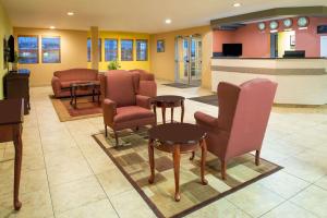 艾尔韦高地艾尔威海兹/斯波坎机场戴斯旅馆及套房酒店的一间设有椅子和桌子的等候室和一个柜台
