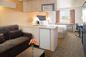 艾尔韦高地艾尔威海兹/斯波坎机场戴斯旅馆及套房酒店的酒店客房,配有床和沙发