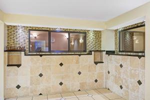 坦帕Days Inn & Suites by Wyndham Tampa - Ybor City的浴室设有两面镜子和瓷砖墙。