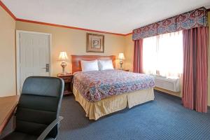阿尔伯克基阿尔伯克基城区戴斯酒店的酒店客房配有一张床、一张桌子和一把椅子。