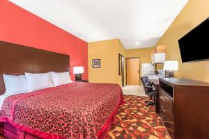 埃尔多拉多Days Inn & Suites by Wyndham El Dorado的配有一张床和一张书桌的酒店客房